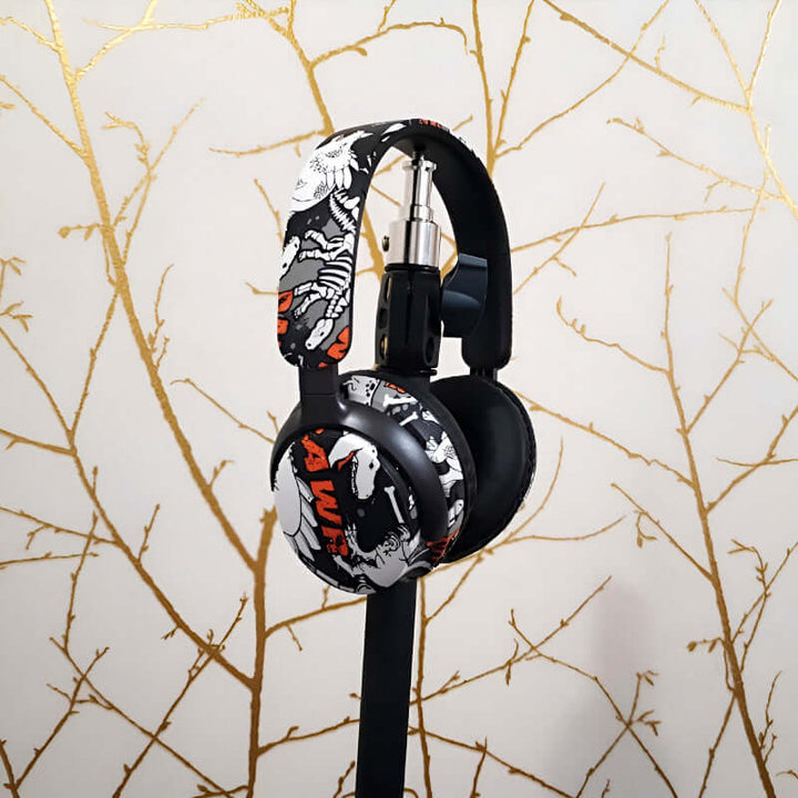 AKZ-38 wireless Bluetooth headphones in graffiti style design on display with decorative background.